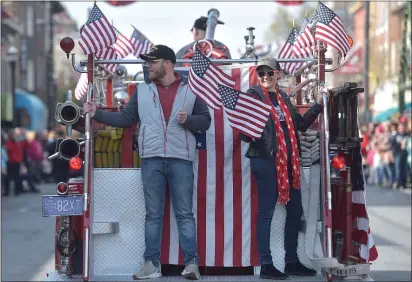  ??  ?? Getting a ride on the back of Clifton Heights antique fire truck in the 60th Annual Delaware County Veterans Day Parade are Army veteran Daniel Fortier and Navy veteran Trish Depompeo.