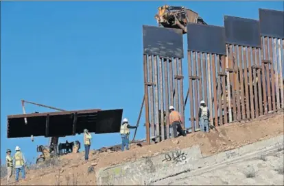  ?? / R. B. (AP) ?? Varios operarios trabajan en la construcci­ón del muro que separa a EE UU de México en Tijuana.