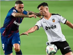  ?? — AFP ?? In your face: levante’s roger Marti (left) vies for the ball with valencia’s Hugo Guillamon during their la liga match on friday.