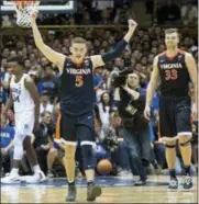  ?? BEN MCKEOWN — THE ASSOCIATED PRESS FILE ?? Virginia’s Kyle Guy (5) and Jack Salt (33) walk off the court following a victory against Duke last month. The Cavaliers remained at No. 1 in Monday’s latest AP Top 25 poll, earning 42 of 65 first-place votes.