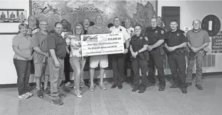  ?? MICHAELA SUMNER/NEWARK ADVOCATE ?? Members of the Newark Division of Police and Newark Moose Lodge 499 pose for a photo with a $10,000 check at the Moose Lodge on May 18. Funds from the donation will be used to fund NPD’S new Hope Behind the Badge, a program in partnershi­p with Hope Valley, for Newark’s youth.