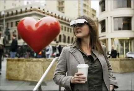  ?? ERIC RISBERG — THE ASSOCIATED PRESS ?? In this photo taken Thursday Yvonne Felix wears eSight electronic glasses and looks around Union Square during a visit to San Francisco. The glasses enable the legally blind to see. Felix was diagnosed with Stargardt’s disease after being hit by a car...