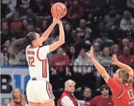  ?? SUE OGROCKI/AP ?? Ohio State guard Celeste Taylor (12) shoots over Maryland guard Faith Masonius in the first half on Sunday in Columbus, Ohio.