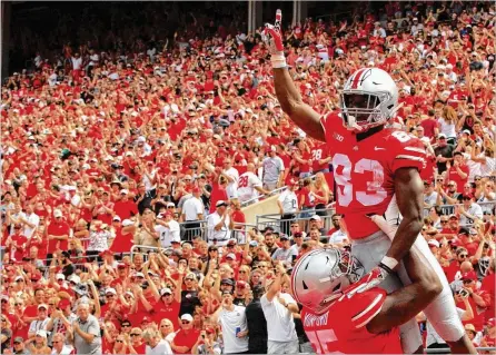  ?? DAVID JABLONSKI / STAFF ?? Ohio State receiver Terry McLaurin gets a lift from Thayer Munford after scoring the Buckeyes’ first touchdown of the season on a 2-yard catch Saturday against Oregon State in Columbus. McLaurin also had a 75-yard scoring reception to start the second half.