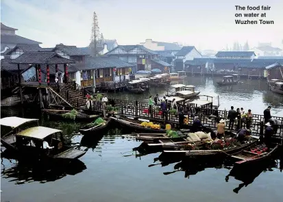  ??  ?? The food fair on water at Wuzhen Town