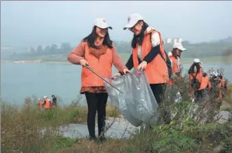  ?? QIN TINGFU / XINHUA ?? Yu Jiaxin (first left), who is studying with the school of mathematic­s and statistics at Southwest University in Chongqing, helps her classmate as they do volunteer work. They are members of Beibei Volunteers, a group in Chongqing. Since its initiation...