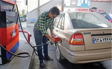  ?? (AFP) ?? A man fills fuel at a petrol station in Tehran on Friday