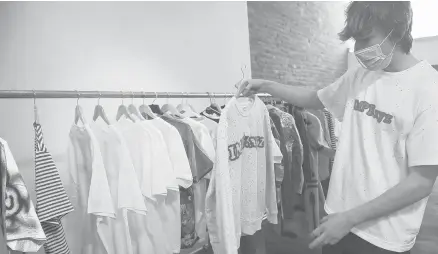  ?? EMILY MATTHEWS/PITTSBURGH POST-GAZETTE PHOTOS ?? High school junior Adam Klenovich holds up a shirt he made for his IMPERFECT clothing line.