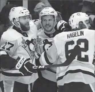  ?? FREDERICK BREEDON, GETTY IMAGES ?? From left, Bryan Rust, Sidney Crosby and Carl Hagelin celebrate Carl Hagelin’s empty-net goal against the Nashville Predators Sunday night.