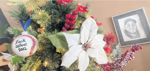  ?? TINA COMEAU • SALTWIRE NETWORK ?? A baseball displaying Zack Lefave’s name and the year his baseball team won Atlantics was included on the family Christmas tree, alongside a sketched photo of Zack that hangs on the wall.