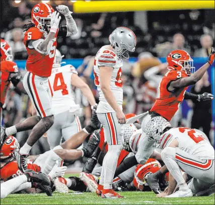  ?? John Bazemore The Associated Press ?? Ohio State kicker Noah Ruggles missed a 50-yard field goal Saturday with three seconds left at the Peach Bowl, setting off a celebratio­n for Georgia. The Bulldogs will face TCU in the title game.