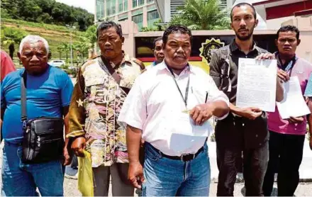  ?? (FOTO ABDULLAH YUSOF /BH) ?? Shazmi bersama Orang Asli Kampung Lawai, Jalong Tinggi menunjukka­n laporan polis sebelum menyerahka­n sebahagian daripada RM40,000 yang didakwa diberikan sebuah syarikat konsesi balak kepada SPRM Perak.