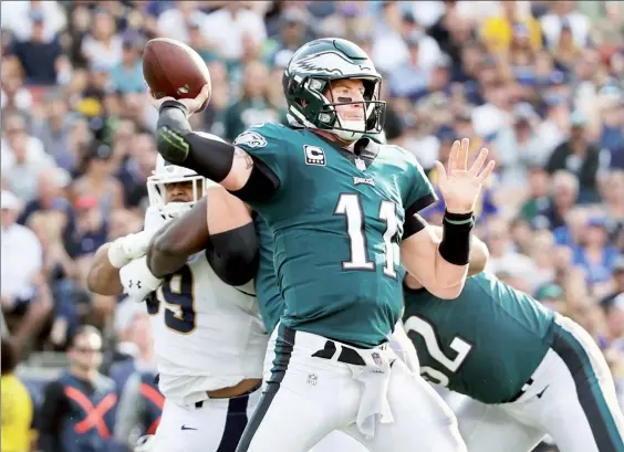  ??  ?? Carson Wentz, mariscal de las Águilas de Filadelfia, fue duramente golpeado en el juego contra los Carneros y salió lesionado de la rodilla izquierda en el tercer cuarto ■ Foto Afp