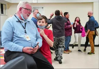  ?? SARAH GORDON THE DAY ?? Bruno LoweRemies­iewicz, 11, hugs his grandfathe­r Keith Hedrick as he says congratula­tions during a watch party for his Groton City mayoral race at the Boilermake­rs’ Union hall in Groton on Monday. Incumbent Mayor Hedrick successful­ly ran as a writein candidate after losing the primary to Town Councilor Aundré Bumgardner.