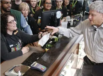  ?? PAUL CONNORS / BOSTON HERALD FILE ?? COMING SOON: Boston’s first recreation­al marijuana shop, Pure Oasis, is moving closer to opening. It will join other ares stores such as Brookline NETA, where Brookline selectman Neil Wishinsky, right, is seen making the first legal marijuana purchase in his town last March from Laura Ross, left,