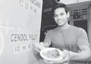  ?? — Gambar Bernama ?? SEDAP: M. Kelvinraj menunjukka­n cendol di gerainya yang terletak di Jalan Yang Kalsom, Ipoh.