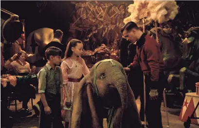  ?? DISNEY ?? Holt Farrier (Colin Farrell) and his children Joe (Finley Hobbins) and Milly (Nico Parker) become caretakers for a flying baby elephant in Tim Burton's “Dumbo.”