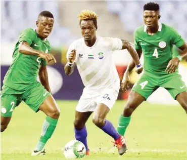  ??  ?? Nathaniel Tongo Vula of Sierra Leone is challneged by Okoro Osadebamwe­n (L) and Aremu Afeez (R) of Nigeria during their 2017 WAFU Cup opening match at the Cape Coast Stadium in Ghana on Monday