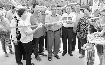  ??  ?? Nyabong cuts the ribbon upon his arrival at Rumah William. With him, from right, are Kapit Youth, Sports and Solidarity officer Rata Tanggai, Inspector Romi Bennet, Kapit Special Affairs officer Jackson Melintang and Bukit Mabong District Officer...