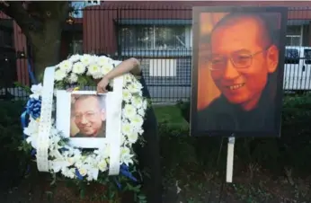 ?? STEVE RUSSELL/TORONTO STAR ?? Members of Toronto’s Chinese community hold a vigil for Liu Xiaobo outside China’s Consolate-General.