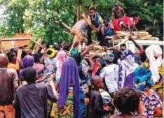  ??  ?? BANGASSOU, Central African Republic: Central African internally-displaced people gather around a truck where volunteers distribute firewood on May 26, 2017. — AFP