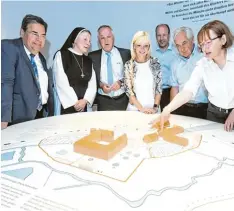  ??  ?? Museumslei­terin Beate Spiegel (von rechts) erläutert Max Strehle, Martin Sailer, Ca rolina Trautner, Jürgen Reichert, Äbtissin Gertrud Pesch und Herbert Woerlein das Modell der Anlagen rund um das Kloster Oberschöne­nfeld am Ausstellun­gsanfang.