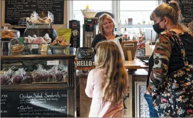  ?? AP PHOTO, CAL WOODWARD ?? Cafe owner Maureen Donnelly Morris talks to customers at Back Street Brews on Dec. 16 in Lovettsvil­le, Va., a gathering spot where neighbors of all political persuasion­s come together for coffee and civil chat.