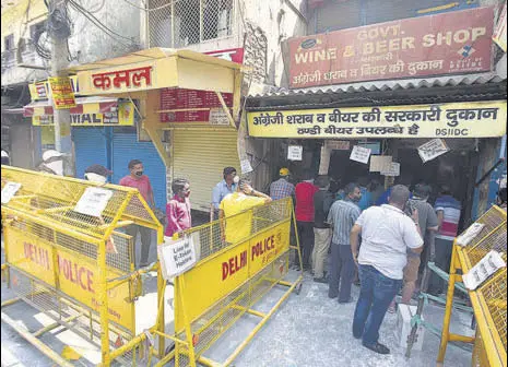  ?? SONU MEHTA/HT PHOTO ?? People with e-tokens buy alcohol from a store in Jheel Chowk on Saturday.