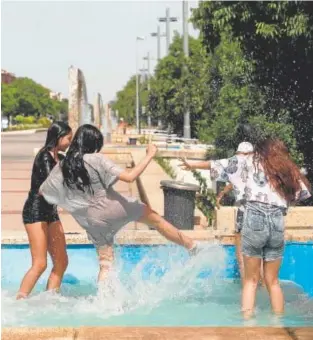  ?? ?? Unas chicas se refrescan de las altas temperatur­as en Córdoba // ÁLVARO CARMONA