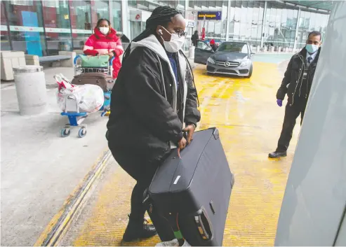  ?? RYAN REMIORZ / THE CANADIAN PRESS ?? Internatio­nal air travellers load their luggage Monday onto a shuttle bus to take them to a quarantine hotel in Montreal. All travellers arriving from abroad now have a mandatory three-day quarantine in a designated hotel.