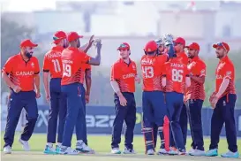  ?? ?? Canada players celebrate the fall of an Oman wicket