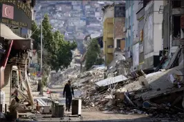  ?? UNAL CAM — THE ASSOCIATED PRESS ?? A man walks past destroyed buildings in Antakya, southeaste­rn Turkey, on Tuesday.