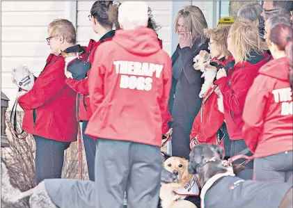  ?? CP PHOTO ?? Whitney Dumas (centre) surrounded by therapy dogs, watches as the casket of her 7-year-old son, Nathan Dumas, is brought to a hearse in Thorold, Ont., Friday.