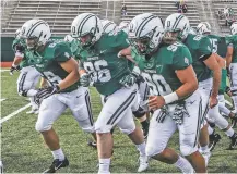  ?? TOM MCNEILL/DARTMOUTH COLLEGE VIA AP ?? During his freshman season at Dartmouth, Seth Simmer, center, was having trouble hearing the linebacker­s’ call signals from his defensive tackle spot just a few yards away. What was first diagnosed as an ear infection brought on by a severe head cold turned out to be a brain tumor that was making him deaf in his left ear. Simmer is one of 30 nominees for the Mayo Clinic Comeback Player of the Year Award.