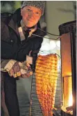  ?? FOTO: BERNHARD LUDEWIG/FINNISCHE BOTSCHAFT ?? Marko Huiskonen von der finnischen Sprachschu­le in Berlin holt den flambierte­n Lachs aus dem Ofen.