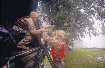  ?? CHRIS SEWARD /ASSOCIATED PRESS ?? Rescue team members Sgt. Matt Locke, left, and Sgt. Nick Muhar from the North Carolina National Guard 1/120th battalion evacuate a family from rising floodwater­s in New Bern, N.C., on Friday.