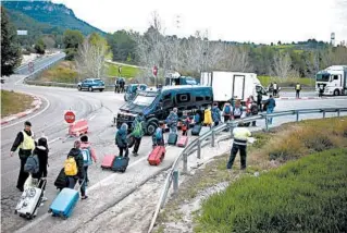  ?? JOAN MATEU/AP ?? Students returning from a school trip change buses after being allowed to enter Igualada, Spain. The government put 60,000 people in four towns on mandatory lockdown Friday.