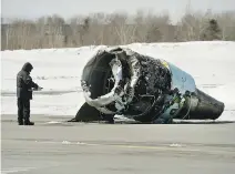  ??  ?? A Transporta­tion Safety Board investigat­or inspects an engine from the Air Canada plane that crash landed Sunday morning at the Halifax airport.