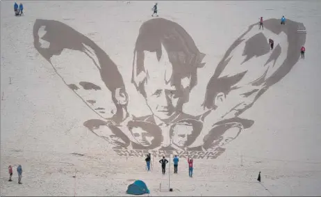  ?? AFP ?? Activists put the finishing touches to a giant sand drawing of the G7 leaders on Watergate Bay beach near Newquay in Cornwall, UK.