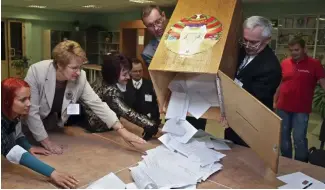  ?? ?? Electoral commission staff count ballot papers after voting closed at a polling station in Minsk, Belarus, on Sept. 23, 2012.