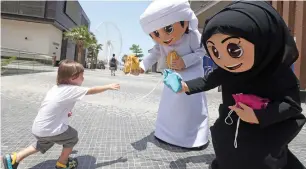  ?? Photo by Dhes Handumon ?? Local characters omeir and ghbeisha distribute goodie bags to kids, as part of the celebratio­n of Hag al Leila, at The Beach, JBr in Dubai on monday. —