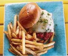  ??  ?? Chicken Parmesan sandwich with fries