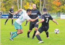  ?? FOTO: RERO ?? Reinhard Bergmann (links) setzt sich mit der SpVgg Lindau gegen den FC Friedrichs­hafen (Mitte: FC-Spielertra­iner Damir Alihodzic) durch.