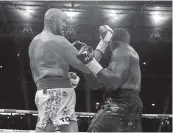  ?? NICK POTTS AP ?? Tyson Fury, left, knocks down Dillian Whyte to win their WBC heavyweigh­t title fight at Wembley Stadium.