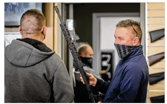  ?? JIM NOELKER / STAFF ?? David Becker, owner of Miami Armory gun shop near the Dayton Mall, talks to a customer Thursday. Becker said new gun owners are from all walks of life. His shop has seen more women shooters in recent years. Becker said recently he has seen people who would generally be anti-gun come into his shop.