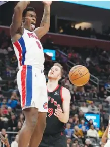  ?? AP PHOTO/CARLOS OSORIO ?? Detroit Pistons center Jalen Duren dunks as Toronto Raptors center Jakob Poeltl watches during the second half of Saturday night’s game in Detroit.