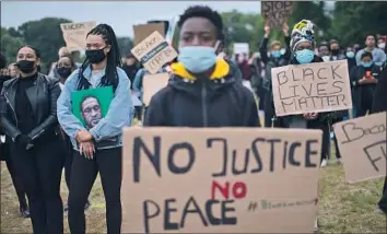  ?? Peter Dejong Associated Press ?? A WOMAN holding a drawing of George Floyd joins others at a Black Lives Matter rally in Amsterdam.