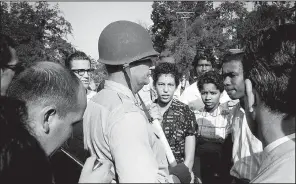  ??  ?? “Surrounded by newsmen … ” a 1997 silver gelatin print of a 1957 photo by Arkansas Democrat photograph­er Will Counts, is part of the “Will Counts: The Central High School Photograph­s” exhibit, opening Tuesday at the Arkansas Arts Center.