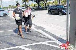  ?? JOE CAVARETTA/SOUTH FLORIDA SUN SENTINEL ?? Mary Coleman and Nikki Carnahan bring flowers to the hit-and-run accident scene in Wilton Manors on Tuesday.