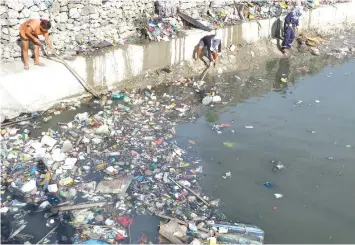  ?? JOY TORREJOS ?? Workers from Cebu City Environmen­t and Natural Resources Office (CCENRO) clean up the Mahiga Creek.